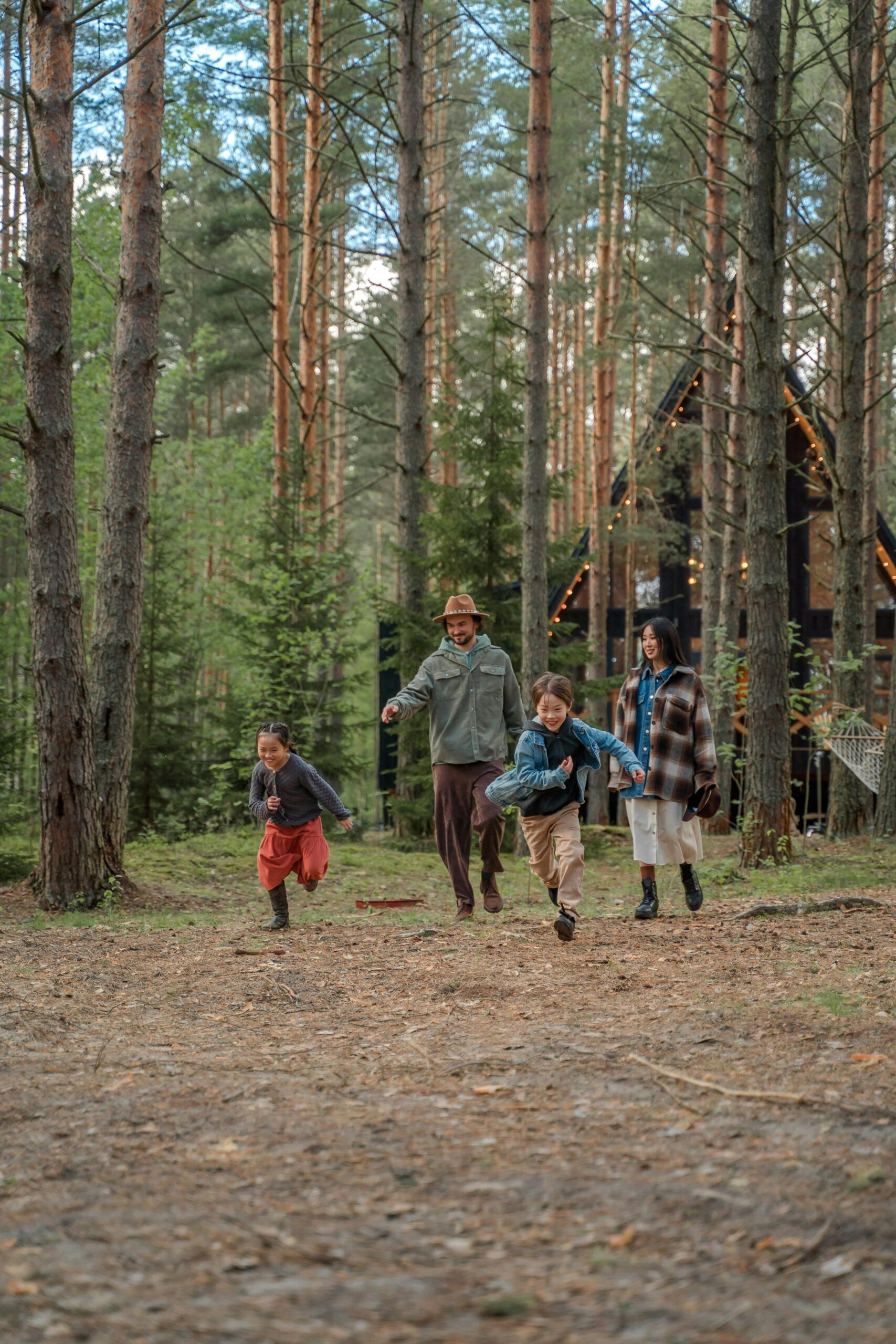Happy family playing and running through the forest, enjoying a vacation together.